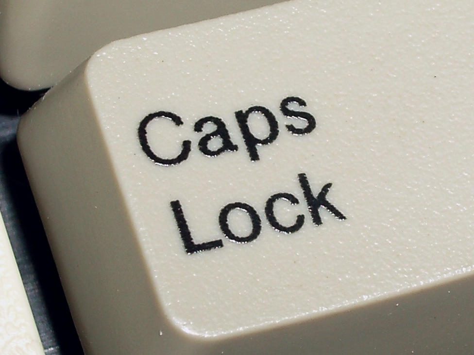 Gros plan d'une touche de clavier beige, la légende « Caps Lock » imprimée en noir.